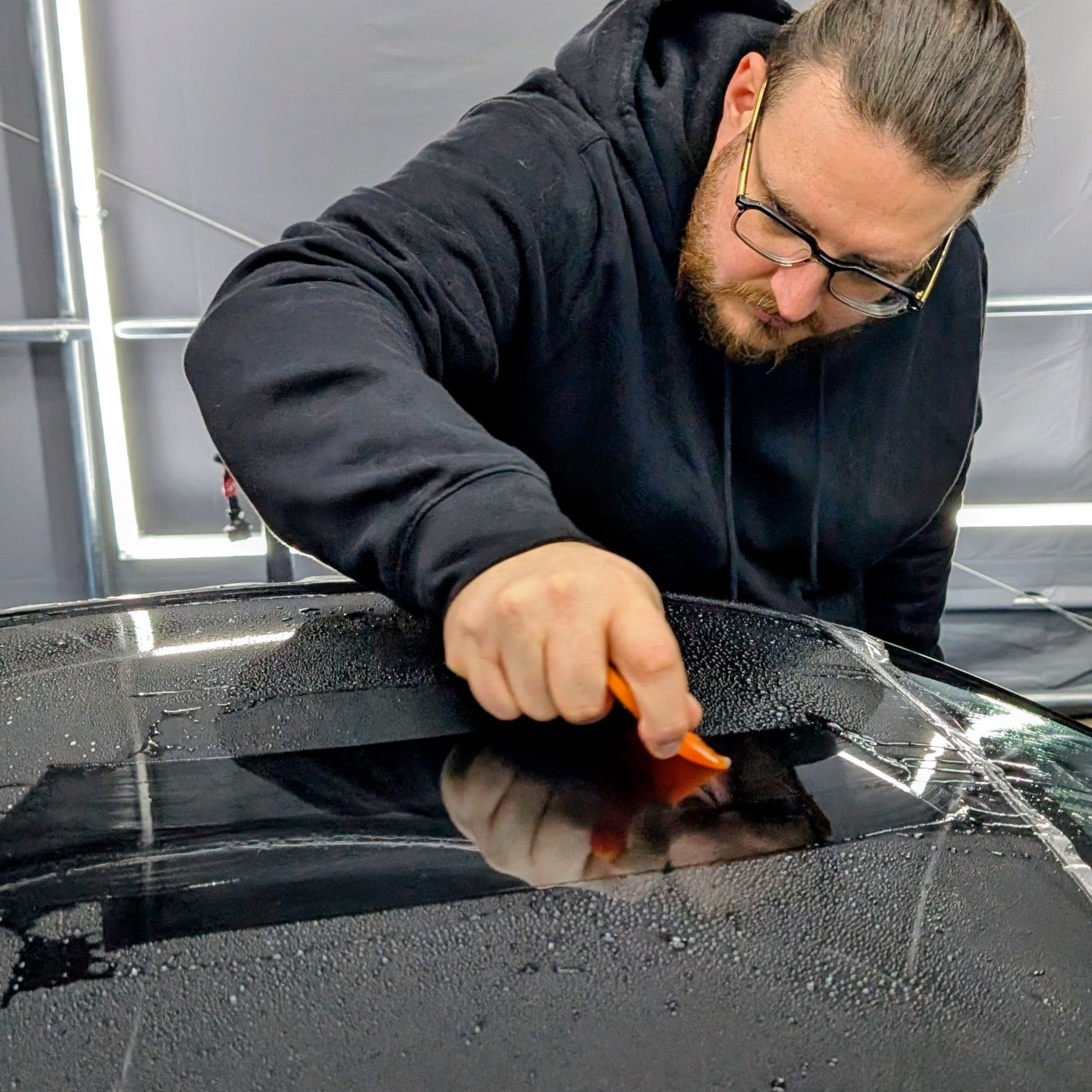 Dimitri Ferraroli fondateur MajesticAuto en train de poser un film PPF