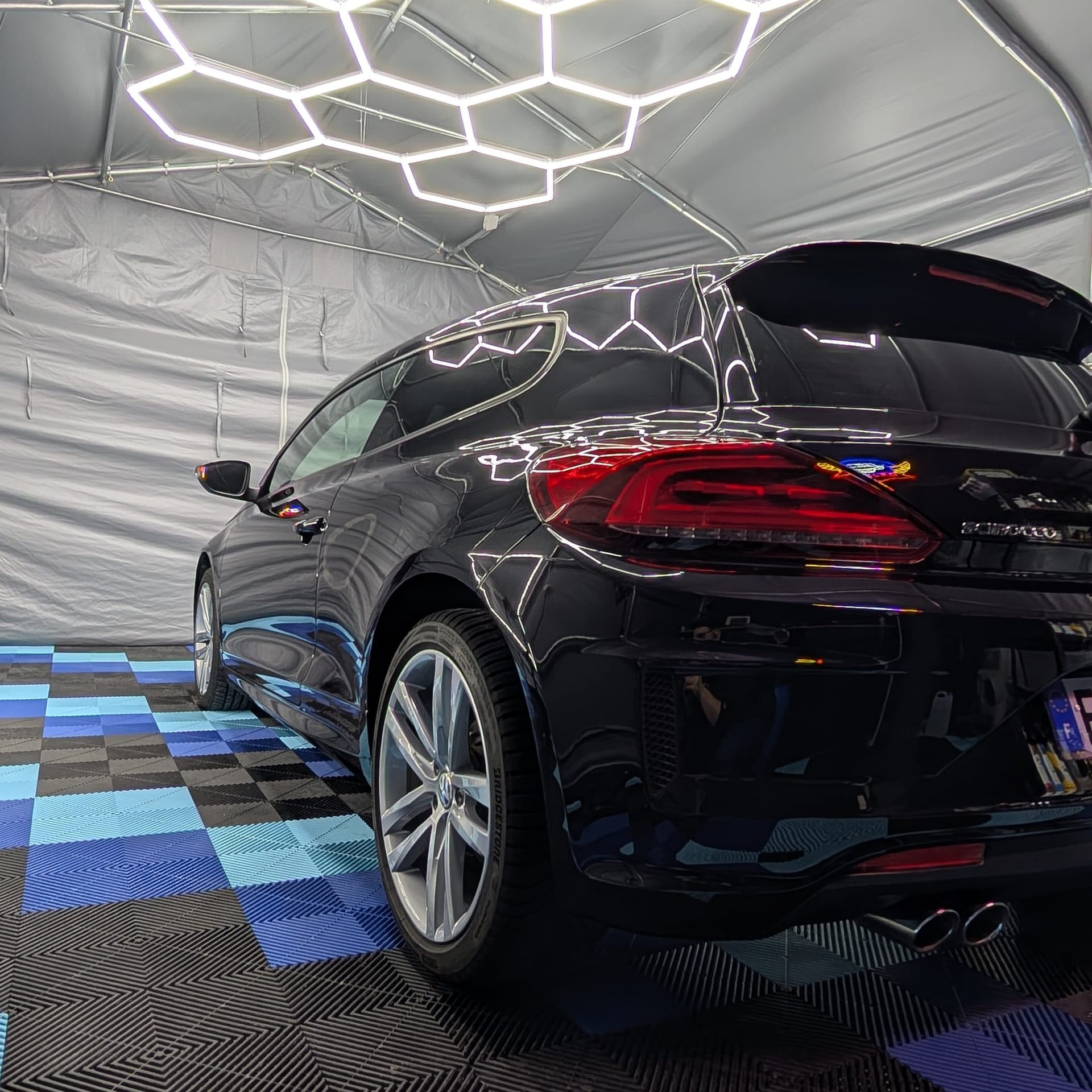 SUV noir après detailing sous éclairage hexagonal